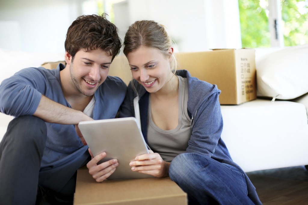 Young couple using tablet to find a home and realtor